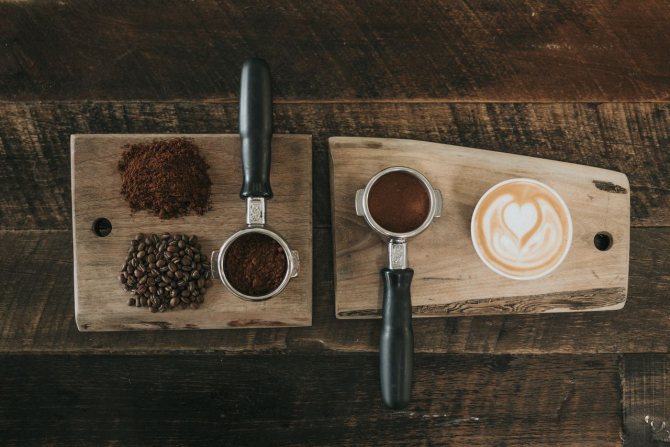 Зерновой кофе, молотый кофе, чашка кофе и темпер для кофе на доске
